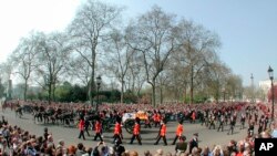 FILE - The gun carriage carrying the coffin of Britain's Queen Mother, is pulled by the Royal Horse Artillery, with members of the royal family following as it enters Horse Guards Parade on its journey to Westminster Hall, in London, Friday April 5, 2002.
