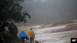 Orang-orang berjalan di sekitar jalan yang terhalang oleh tanah longsor di San Cristobal Verapaz, 7 November 2020, setelah Badai Eta. (Foto: AP)