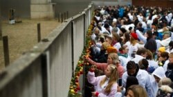 Građani stavljaju cveće u pukotine ostataka Berlinskog zida, na ceremoniji obeležavanja 30-te godišnjice pada zida, u Bernauer ulici u Berlinu.