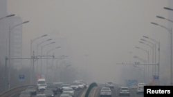 Kabut asap tampak melingkupi langit Kota Beijing, China, di tengah kendaraan yang lalu lalang di kota tersebut pada 13 Februari 2021. (Foto: Reuters/Carlos Garcia)