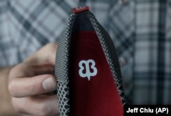 In this Feb. 15, 2018 photo, Betabrand CEO Chris Lindland holds up a shoe while being interviewed at a Betabrand store in San Francisco.