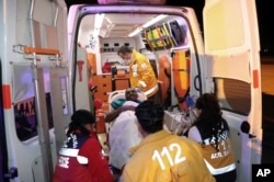 Turkish medics carry a wounded person after a Turkish air ambulance carrying 35 people wounded in a massive truck explosion in Mogadishu, Somalia, landed at a military base just outside the capital Ankara, Turkey, Oct . 16, 2017.