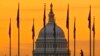 A pedestrian walks through the U.S. Flags on the National Mall and past the U.S. Capitol Building in Washington, Nov. 7, 2022, one day before the midterm election will determine the control of the U.S. Congress.