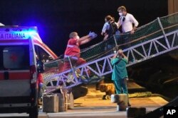Migrants disembark from the Norway-flagged Geo Barents rescue ship carrying 572 migrants in Catania's port, Sicily, southern Italy, Oct. 6, 2022.