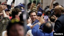 Le gouverneur de Floride, Ron DeSantis, pose pour un selfie avec des partisans, alors qu'il part après avoir pris la parole lors d'un rassemblement, avant les élections de mi-mandat, à Hialeah, Floride, États-Unis, le 7 novembre 2022.