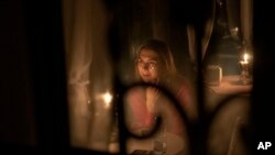 A woman sits in a caffe during a blackout in Kyiv, Ukraine, Nov. 4, 2022.