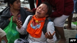 Seorang perempuan menangis, menunggu Tim SAR yang sedang mencari keluarganya di Palu.