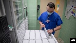 U.S. Air Force 2nd Lt. Kaelan Hayes, a clinical nurse assigned to the military medical team deployed to Brockton, Mass., gathers medication as part of the COVID-19 response operations at Signature Healthcare Brockton Hospital, March 15, 2022. (Sgt. Kaden D. Pitt/U.S. Army via AP)