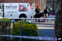 Bomb squad personnel search a moving van during an ongoing investigation in the Brooklyn borough of New York, April 12, 2022.