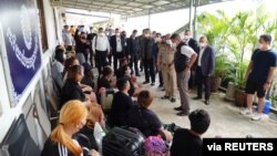 រូបឯកសារ៖ រូបថតដែលចែកចាយដោយប៉ូលិសថៃកាលពីថ្ងៃទី ១២ ខែមេសា ឆ្នាំ ២០២២ បង្ហាញមេបញ្ជាការប៉ូលិសថៃលោក Surachate Hakparn និយាយជាមួយជនរងគ្រោះដែលត្រូវបានសង្គ្រោះពីភ្នំពេញ ប្រទេសកម្ពុជា ដែលពាក់ព័ន្ធនឹងករណីបង្ខាំងឲ្យធ្វើការ។ 