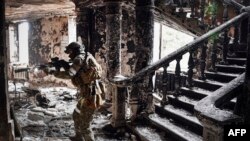 Ruski vojnik u bombardovanoj zgradi pozorišta u Marijupolju, 12. april 2022.