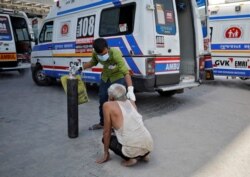 A patient with breathing problem is helped by a relative to enter a COVID-19 hospital for treatment in Ahmedabad, India, April 19, 2021.