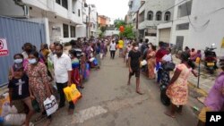 ពលរដ្ឋ​ស្រីលង្កា​តម្រង់​ជួរ​នៅ​ជិត​ស្ថានីយ​ប្រេងសាំង​មួយ​កន្លែង​ដើម្បី​ទិញ​ប្រេងកាត​នៅ​ទី​ក្រុង​កូឡុំបូ កាល​ពី​ថ្ងៃ​១២ ខែ​មេសា ឆ្នាំ​២០២២។ (AP)