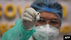 រូបឯកសារ៖ បុគ្គលិកសុខាភិបាលមួយរូបកាន់ដបវ៉ាក់សាំងបង្ការជំងឺកូវីដ១៩ ស៊ីណូហ្វាម (Sinopharm) របស់ប្រទេសចិន នៅមន្ទីរពេទ្យកាល់ម៉ែត រាជធានីភ្នំពេញ កាលពីថ្ងៃទី១០ ខែកុម្ភៈ ឆ្នាំ២០២១។ 