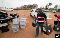 An electoral worker delivers boxes to a district counting center in Kampala, Uganda, Feb. 20, 2016.