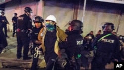 FILE - In this May 31, 2020, photo, Los Angeles police officers arrest a demonstrator where Police Department is investigating 56 allegations of misconduct during protests against police brutality in the wake of George Floyd's death. 