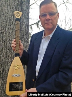 默德牧师手持军方颁发的奖章 （照片来源：Liberty Institute）