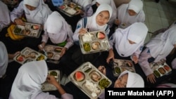 Siswa menikmati makan siang pada hari pertama program makan gratis di SMP Negeri 12 Cimahi, Jawa Barat, 6 Januari 2025. (Foto: Timur Matahari/AFP)