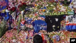 A man throws flowers outside Kanjuruhan Stadium where a soccer stampede killed more than 100 people on Saturday, in Malang, East Java, Indonesia, Oct. 4, 2022