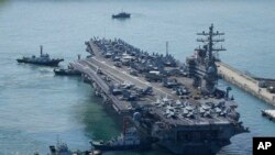 资料照片：2022年9月23日，美国“罗纳德·里根”号航母在护送下抵达韩国釜山。2022年10月6日，朝鲜向东部海域发射了两枚短程弹道导弹。