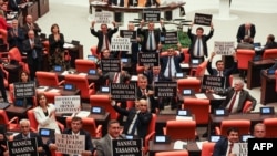 Opposition Republican People's Party deputies hold signs as they protest against a government-backed bill that criminalizes "disinformation," at the Grand National Assembly of Turkey in Ankara, Oct. 4, 2022. 