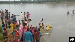 Dalam gambar yang diambil dari video ini, orang-orang mencari korban kapal yang terbalik karena kelebihan muatan di Sungai Karato, Panchagarh, Bangladesh, Minggu, 25 September 2022. (AP)