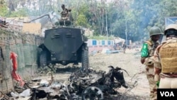 The wreckage of the first car bomb that exploded at the entrance of Lama-Galay. African Union forces can be seen at the scene after the explosions, October 3, 2022.