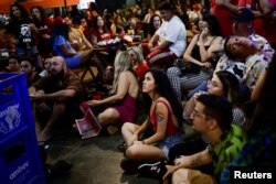 People observe a debate ahead of the runoff election between Brazil's President and candidate for re-election Jair Bolsonaro and former President and current candidate Luiz Inacio Lula da Silva, at a bar in Brasilia, Brazil Oct. 28, 2022.