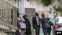FILE - Former Nigerian president Olusegun Obasanjo (2ndL) is greeted as he arrives for the peace talks between the Ethiopian government and Tigrayan People's Liberation Front at the Department of International Relations and Cooperation headquarters in Pretoria, Oct. 26, 2022.