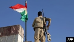 FILE - A Kurdish peshmerga fighter affiliated with the Iranian Kurdistan Democratic Party stands guard on a building following an Iranian cross-border attack in Koye, in Iraqi Kurdistan, Oct. 1, 2022. 