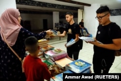 Schoolboys collect unedited textbooks as part of a protest in East Jerusalem October 1, 2022. (REUTERS/Ammar Awad)