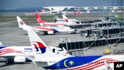 FILE - Malaysia Airlines planes taxi at a terminal at Kuala Lumpur International Airport in Sepang, Malaysia, April 1, 2022.