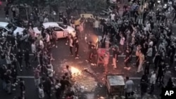 Warga Iran memprotes kematian wanita 22 tahun Mahsa Amini setelah dia ditahan oleh polisi moral, di Teheran, 20 September 2022. (Foto: AP)