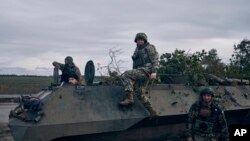 Ukrainian servicepeople pose for a photo with their armored vehicle near Bakhmut, Donetsk region, Ukraine, Oct. 22, 2022.