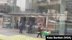 Armed guards are seen positioned at a shopping center’s entrance in the Sandton area of Johannesburg, South Africa, Oct. 27, 2022.