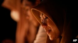 A supporter of soccer club Arema FC prays for the victims of Saturday's soccer match stampede outside the Kanjuruhan Stadium in Malang, Indonesia, Oct. 3, 2022.