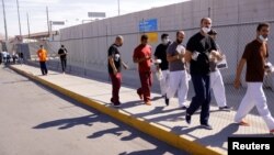 FILE - Cuban migrants who were expelled from the U.S. and sent back to Mexico under Title 42 walk near the at the Lerdo Stanton International border bridge, in Ciudad Juarez, Mexico, May 3, 2022.