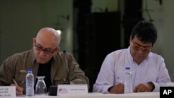 Antonio Garcia, of the Colombian guerrilla National Liberation Army (ELN), left, and Colombian government representative Ivan Danilo Rueda sign an agreement to resume peace talks, at the Casa Cultural Aquiles Nazoa in Caracas, Venezuela, Oct. 4, 2022.