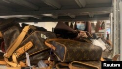 A customer looks at bags displayed at a store of second-hand luxury goods platform ZZER in Shanghai, China September 9, 2022.