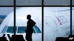 FILE - A passenger waits for a flight at Hartsfield-Jackson International Airport in Atlanta, Feb. 18, 2021. The airport was among those that experienced website issues Oct. 10, 2022, in an apparent coordinated denial-of-service attack. Officials said flights were not affected.