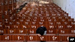 A 19-year old Hazara Afghan girl sits and cries on the bench she was sitting on during Friday's suicide bomber attack on a Hazara education center, in Kabul, Oct. 1, 2022.
