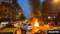 Sebuah sepeda motor polisi dibakar saat protes atas kematian Mahsa Amini, seorang perempuan yang meninggal setelah ditangkap oleh "polisi moral" di Teheran, Iran 19 September 2022. (Foto: via Reuters)