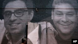 2015-ci ildən İranda həbsdə olan Siyamək Namazi (solda) şəkli Vaşinqtonda divarda