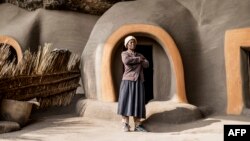 Malefakome, 54 ans, pose devant ses habitations dans le district de Berea au Lesotho le 9 octobre 2022.