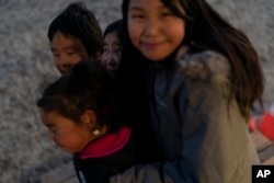 Children play in Shishmaref, Alaska, Friday, Sept. 30, 2022.