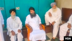 Harbans Singh (second from left), who left Afghanistan recently talks to other members of the community at the Sikh temple where he is living after arriving in New Delhi. (Anjana Pasricha/VOA)