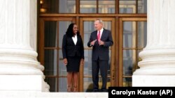 Le juge associé de la Cour suprême Ketanji Brown Jackson se tient devant la Cour suprême avec le juge en chef des États-Unis John Roberts, à la suite de sa cérémonie d'investiture officielle à la Cour suprême de Washington, le vendredi 30 septembre 2022.