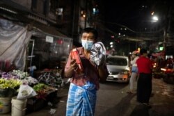 A man attends a night protest against the military coup in Yangon, Myanmar, Feb. 5, 2021.