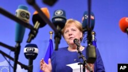 German Chancellor Angela Merkel speaks with the media at the conclusion of an informal EU summit on migration at EU headquarters in Brussels, Sunday, June 24, 2018.