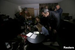 FILE - News media look at documents left inside the home of suspects Syed Rizwan Farook and Tashfeen Malik in Redlands, California, following Wednesday's attacks, Dec. 4, 2015.